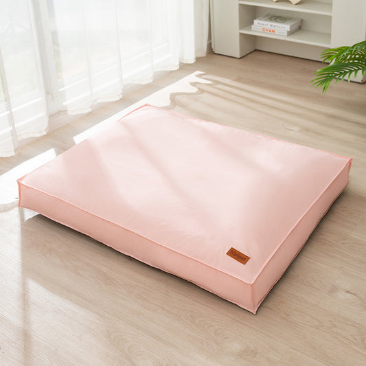 Pink pet bed on a wooden floor with a white curtain in the background