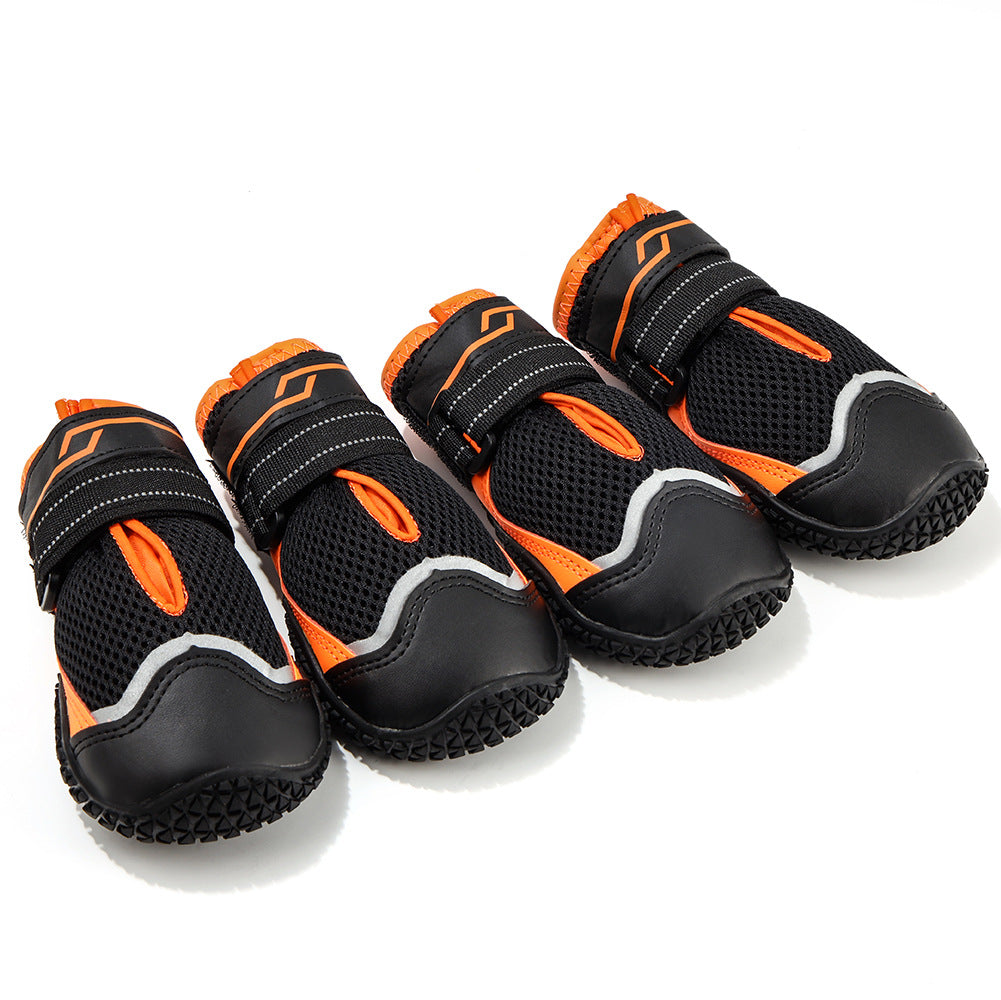 Four black and orange dog boots on a white background