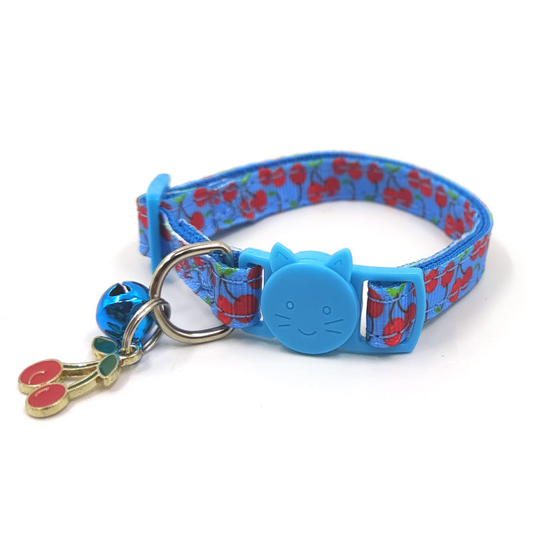 Blue cat collar with cherry pattern and decorative charm on a white background