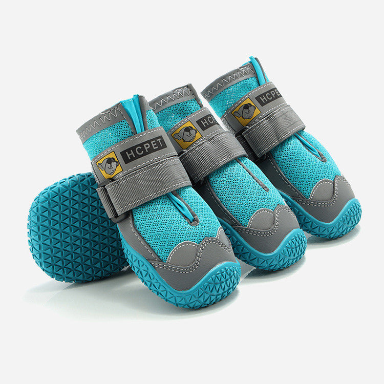 Pair of turquoise pet boots with gray straps on a white background