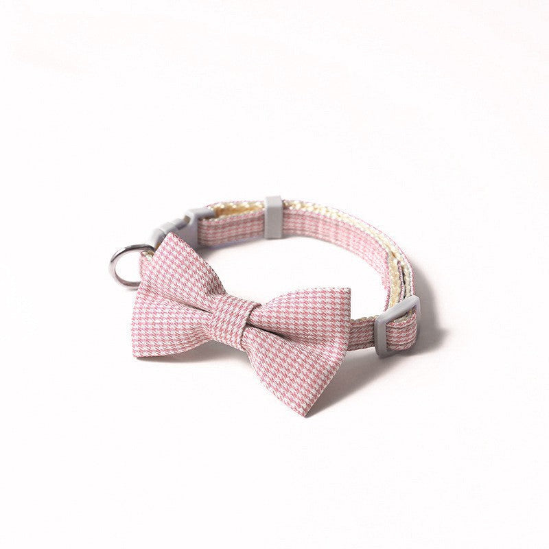 Dog collar with a pink bow tie on a white background