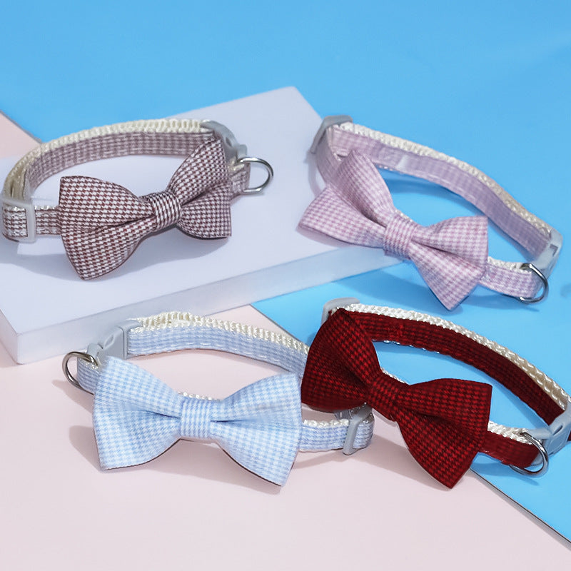 Four dog collars with bow ties on a blue and pink gradient background