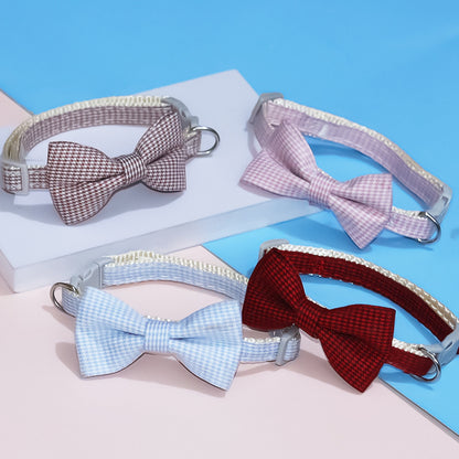 Four dog collars with bow ties on a blue and pink gradient background