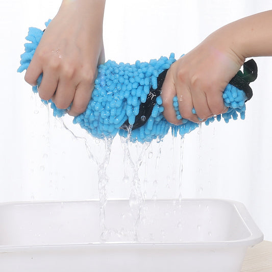 Blue scrubber with water being poured over it, held by hands against a white background