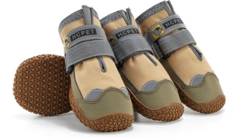 Pair of beige and brown pet shoes with gray straps on a white background